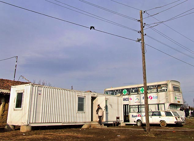 Болница из Косовог Поља (фотографија горе) након Погрома 17. марта 2004. измештена је у овај аутобус и контејнере након тога. У овим "објектима" је функционисала извесно време док се није преселила у оближњу приватну кућу у којој се и данас налази. / Фото: Иван Максимовић / КМ Новине