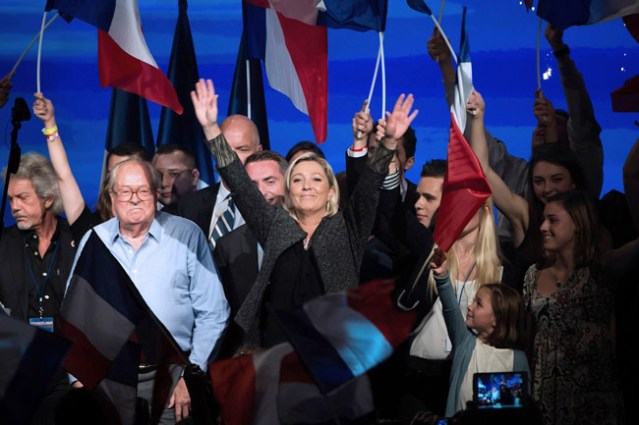 French far-right Front National (FN) party President Marine Le Pen (C) and her father and FN honour president Jean-Marie Le Pen (2nd L) acknowledge the audience after delivering a speech during the FN summer congress on September 15, 2013 in Marseille, southern France. AFP PHOTO / BERTRAND LANGLOIS (Photo credit should read BERTRAND LANGLOIS/AFP/Getty Images)