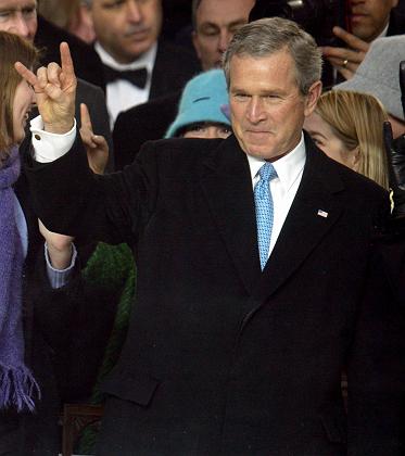 U.S. President George W. Bush gestures from the reviewing stand of the inaugural parade as a Texas float goes past in Washington, January 20, 2005. Bush was sworn in for a second term in office earlier in the day. REUTERS/Larry Downing