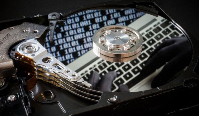 Symbolic Photo about privacy. Closeup of a hard drive on a laptop and a binary reflected. Berlin, Image: 228585604, License: Royalty-free, Restrictions: , Model Release: yes, Credit line: Profimedia, Alamy