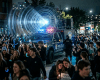 Police vehicle with loudspeaker and flashing lights among crowd at night